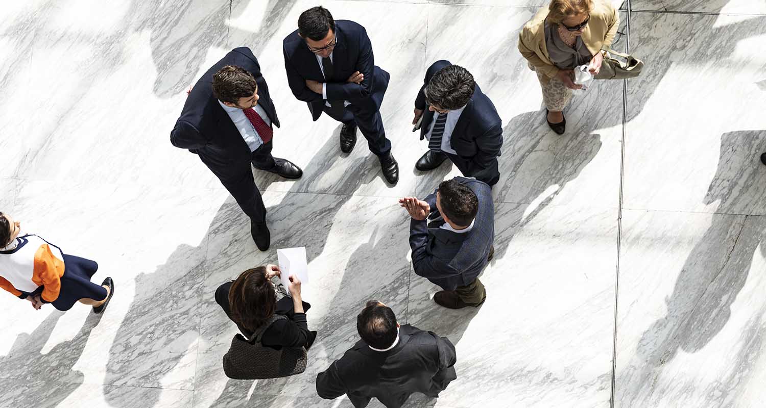 Vista en picado de varias personas hablando en circulo en un hall