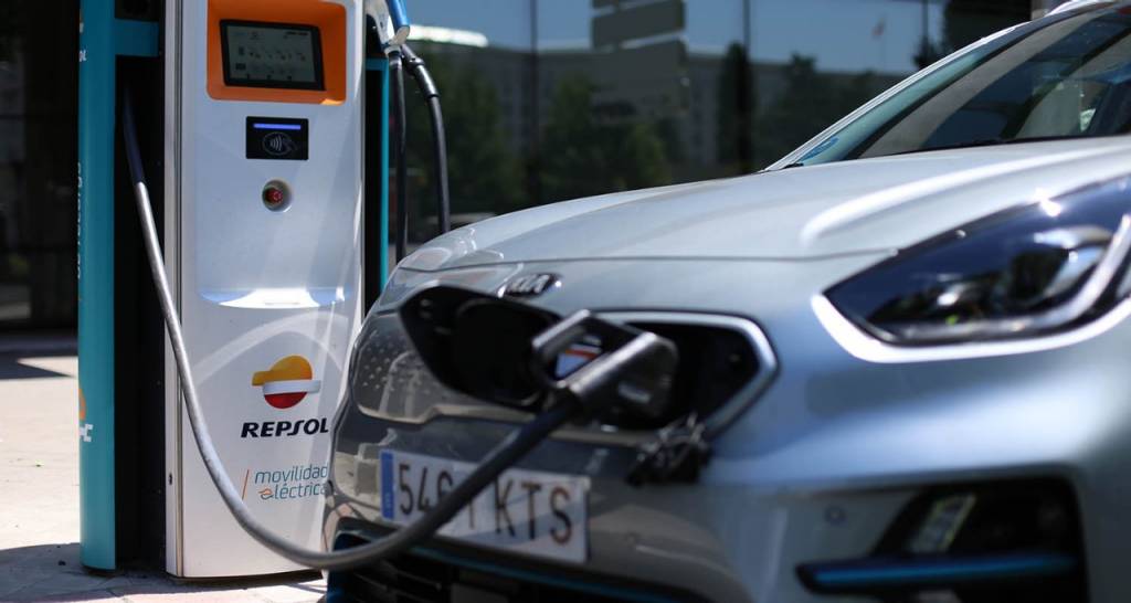 Una mujer observa la recarga de un coche eléctrico