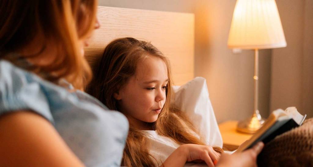 Madre e hija de noche en un dormitorio