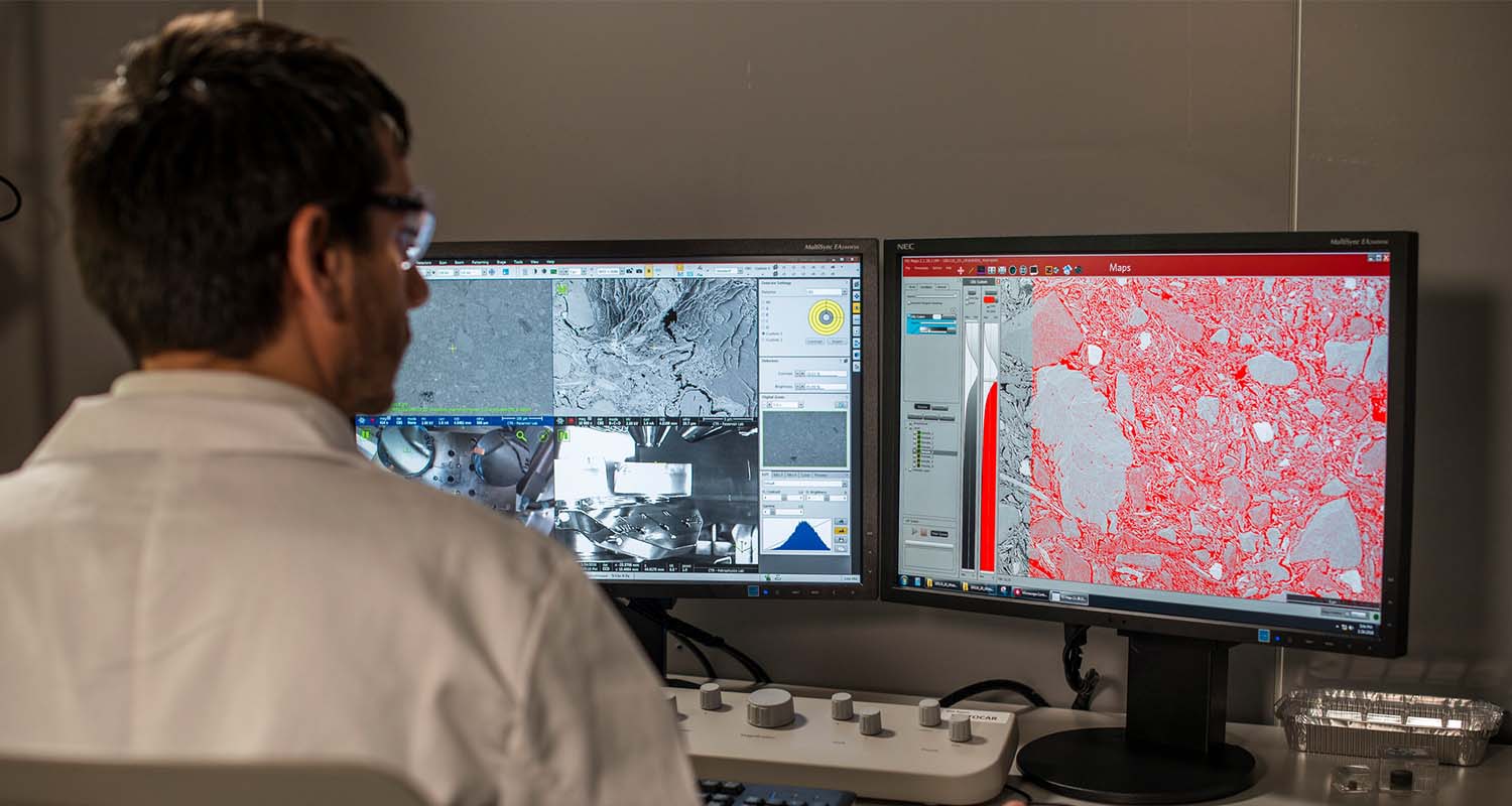 A man analyzing data and maps on two screens