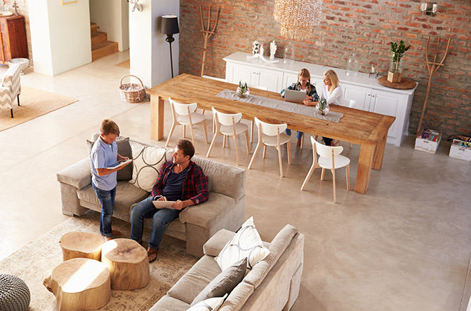 Una familia reunida en el salón de su casa en plano picado.