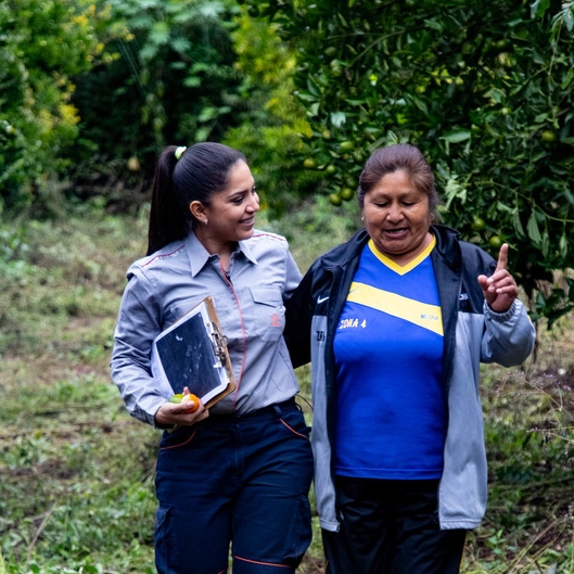 Repsol employee and Bolivian woman walk holding hands