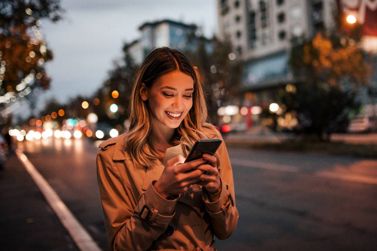 A woman looking at her smartphone on the street